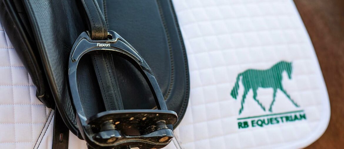 Flex-on stirrups on a saddle pad embroidered with the RB Equestrian logo