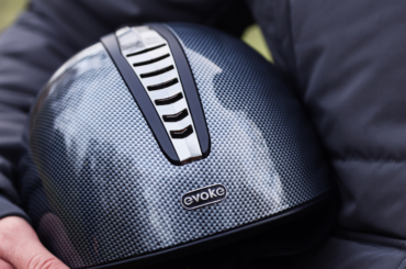 A rider carrying an Evoke riding helmet