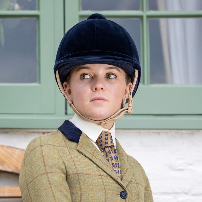 A rider wearing a navy riding hat