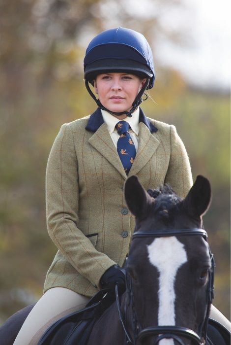A rider wearing a showjacket and riding on a horse