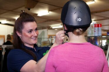 RB Equestrian's manager fitting a riding hat to a customer