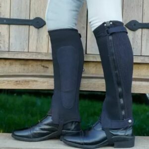 A pair of chaps covering a pair of riding boots